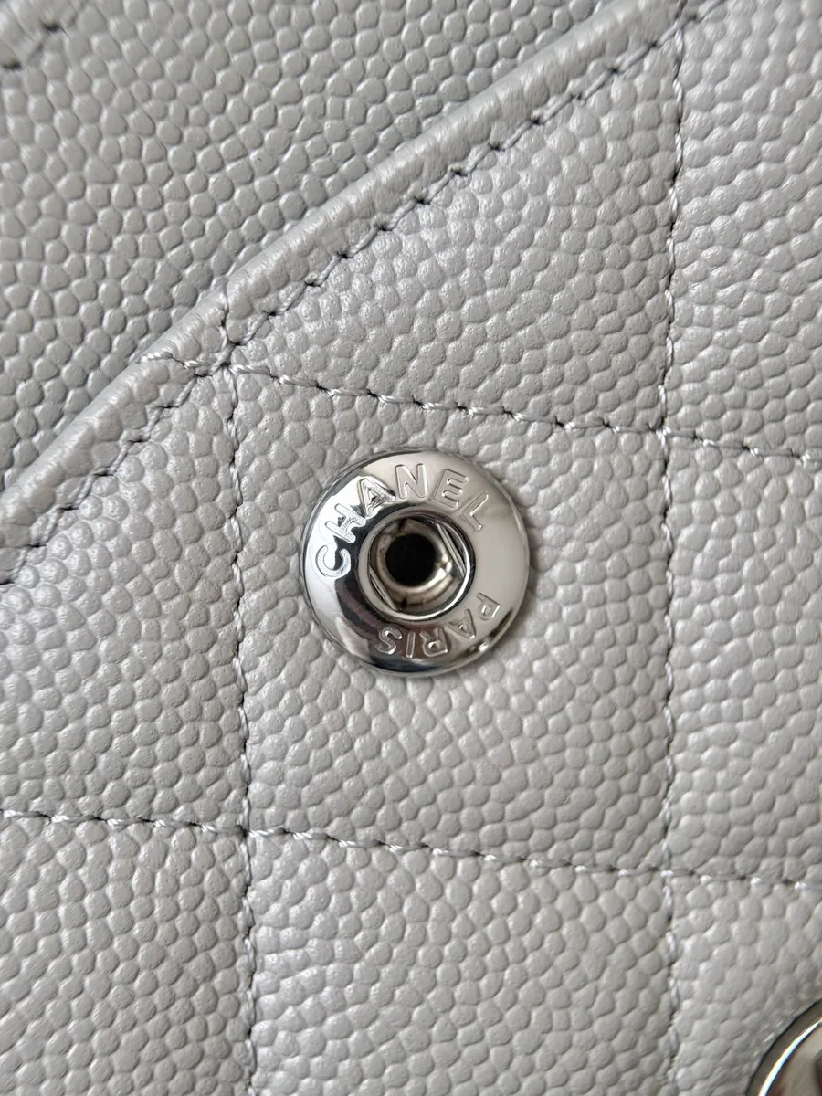 Крупный план металлической кнопки-застежки с гравировкой Chanel Paris