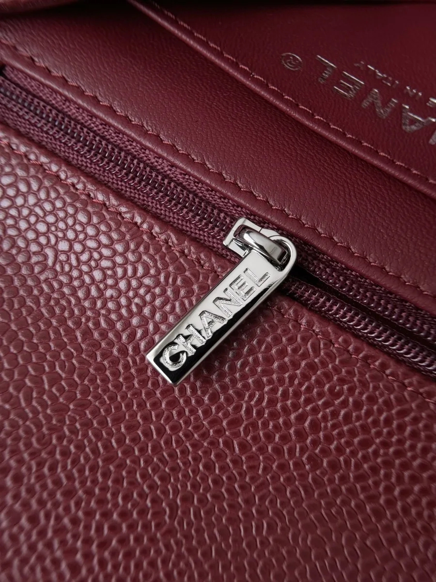 Крупный план серебристого бегунка молнии с надписью Chanel