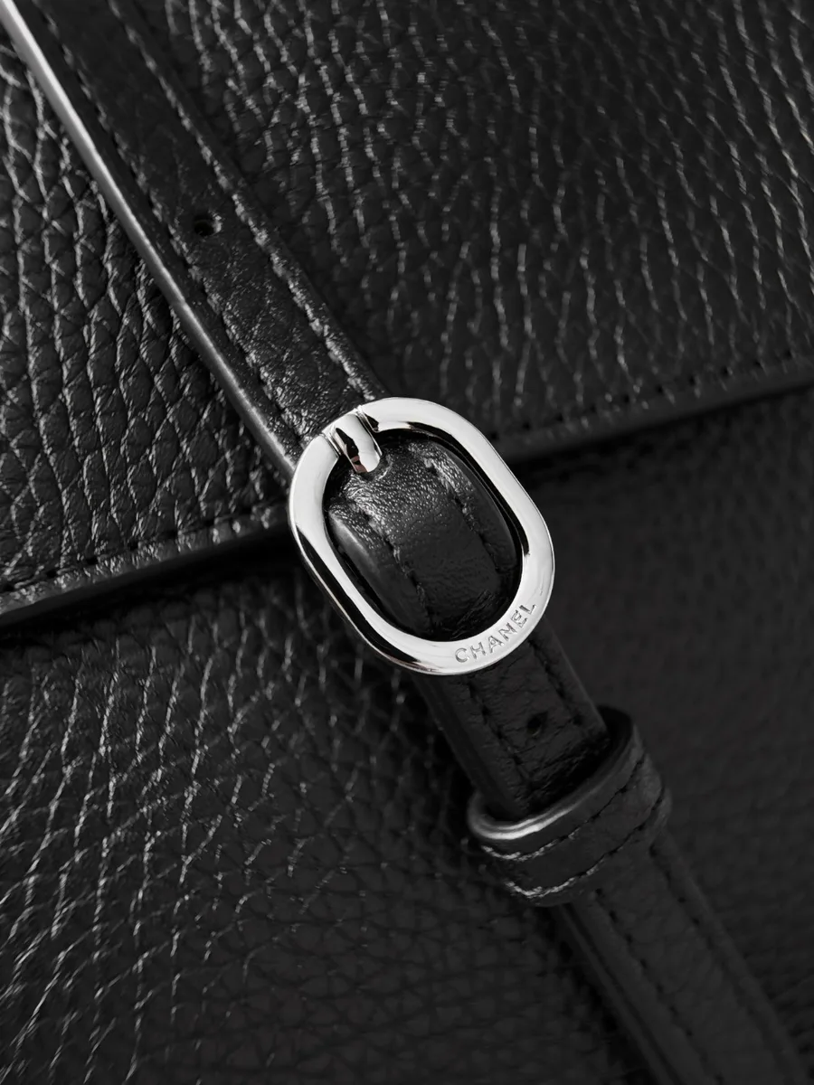 Серебристая пряжка на черном кожаном плечевом ремне с гравировкой Chanel