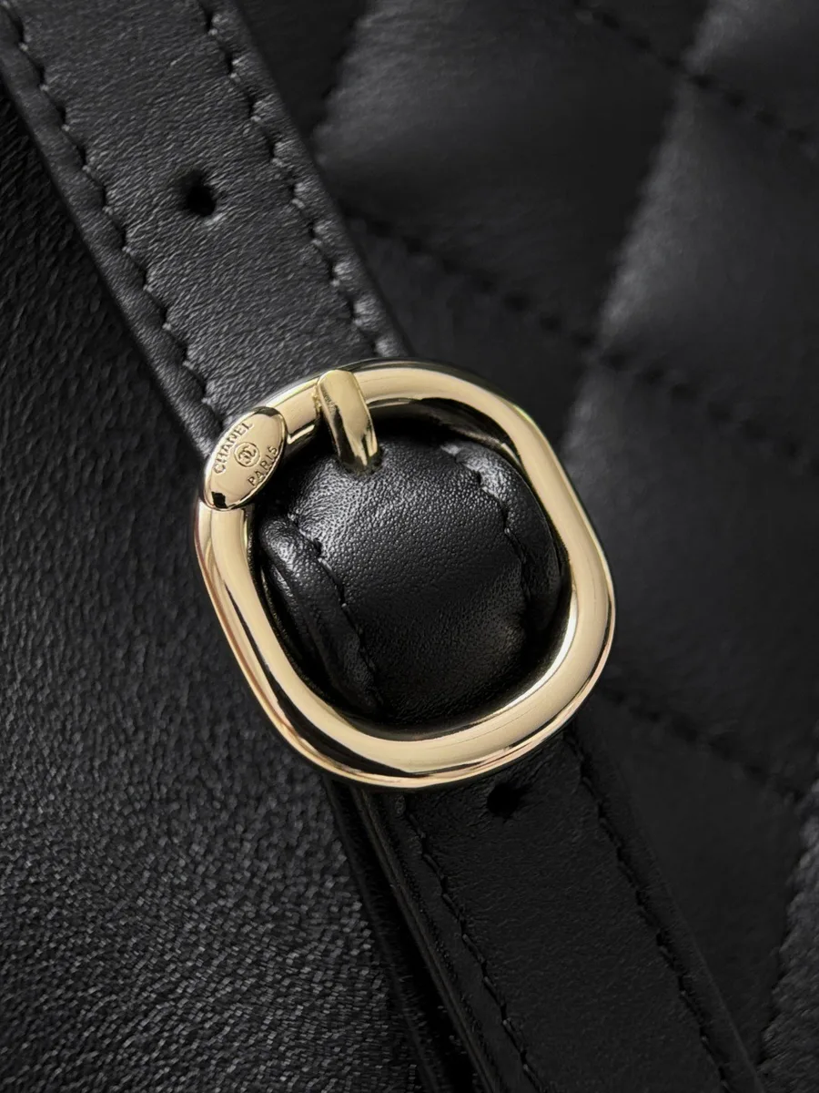 Золотистая пряжка на кожаном ремешке рюкзака Chanel.