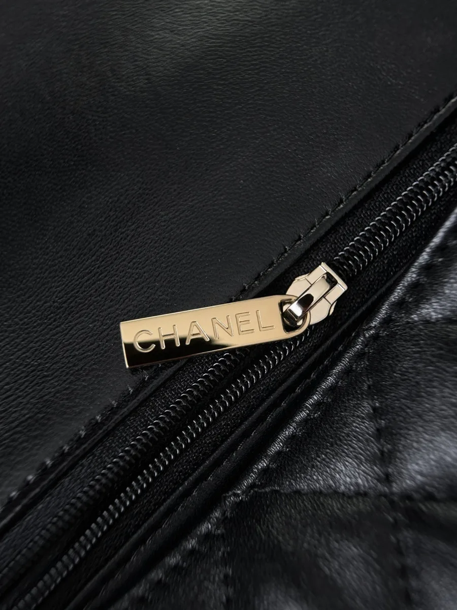 Золотистый пуллер молнии с гравировкой Chanel крупным планом