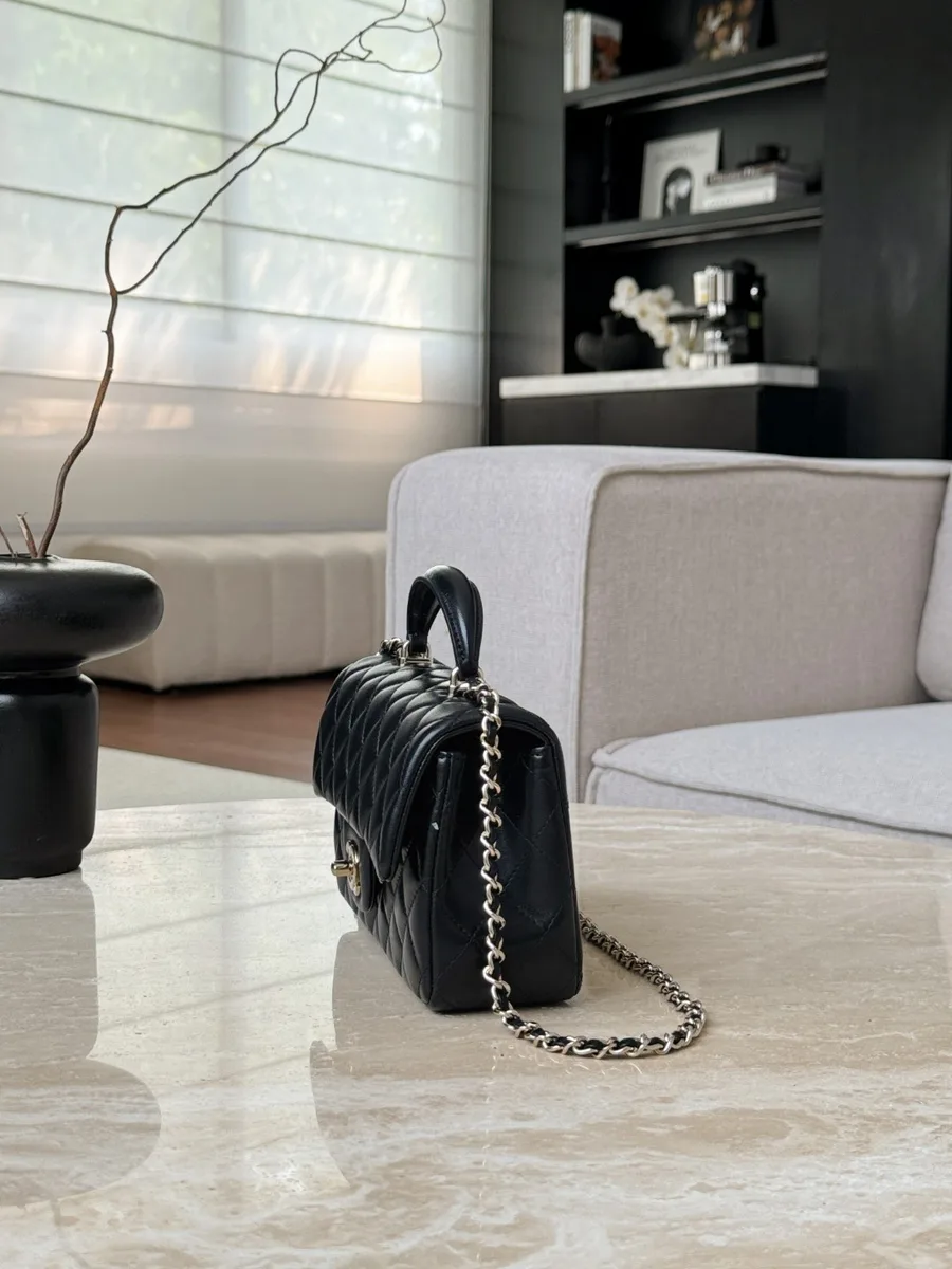 Боковая сторона чёрной стёганой сумки Chanel Mini Handle Bag