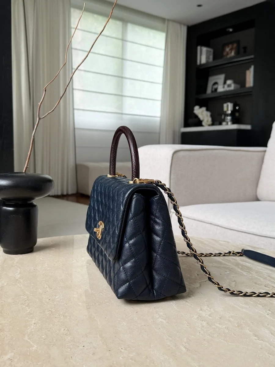 Боковой ракурс синей сумки Chanel Coco Handle, демонстрирующий форму и объем