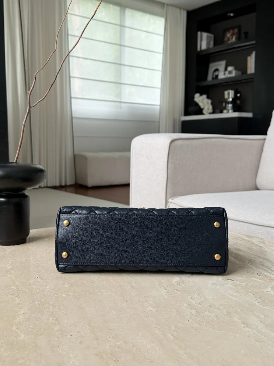 Нижняя часть синей сумки Chanel Coco Handle с четырьмя защитными металлическими ножками