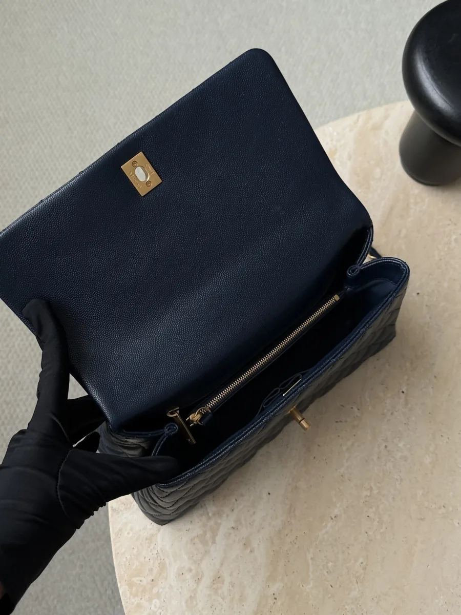 Вид сверху на открытую синюю сумку Chanel Coco Handle с внутренними отделениями