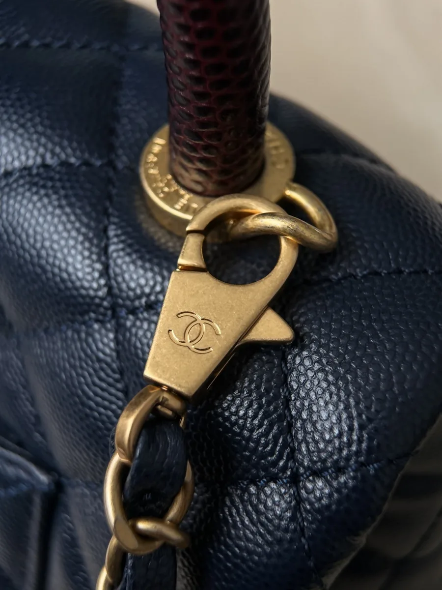 Золотистый карабин плечевого ремня-цепочки синей сумки Chanel Coco Handle