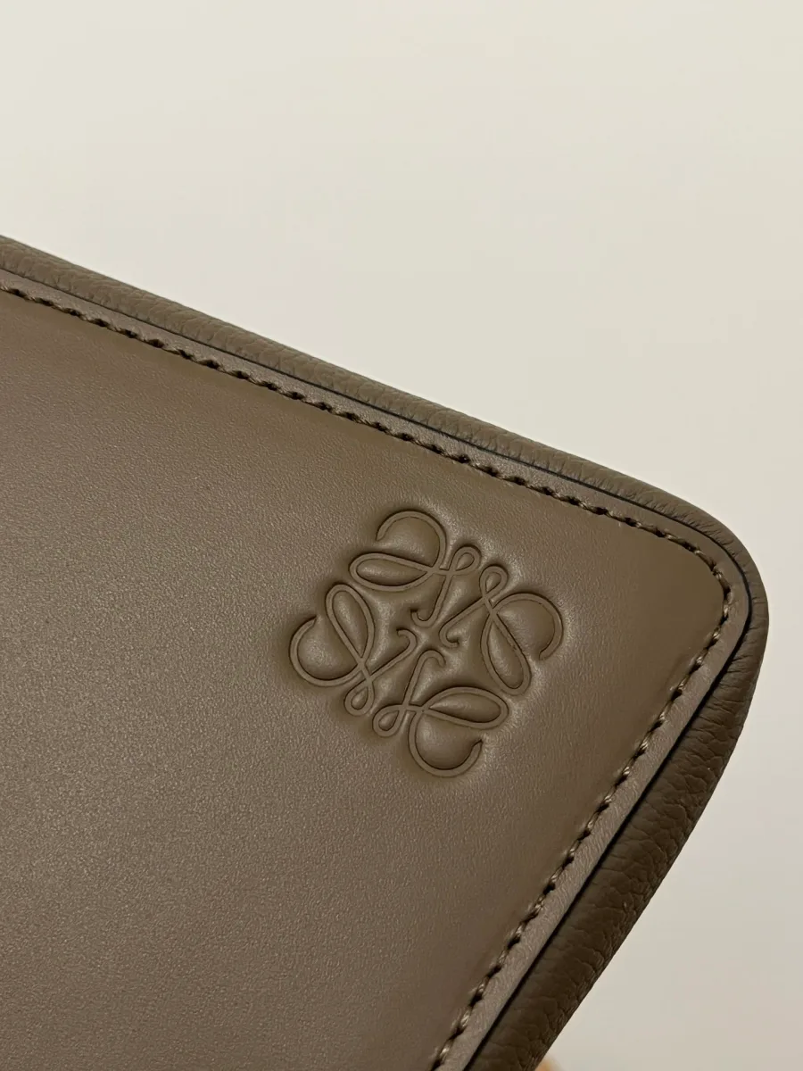 Тиснёный логотип-анаграмма Loewe на гладкой кожаной вставке сумки