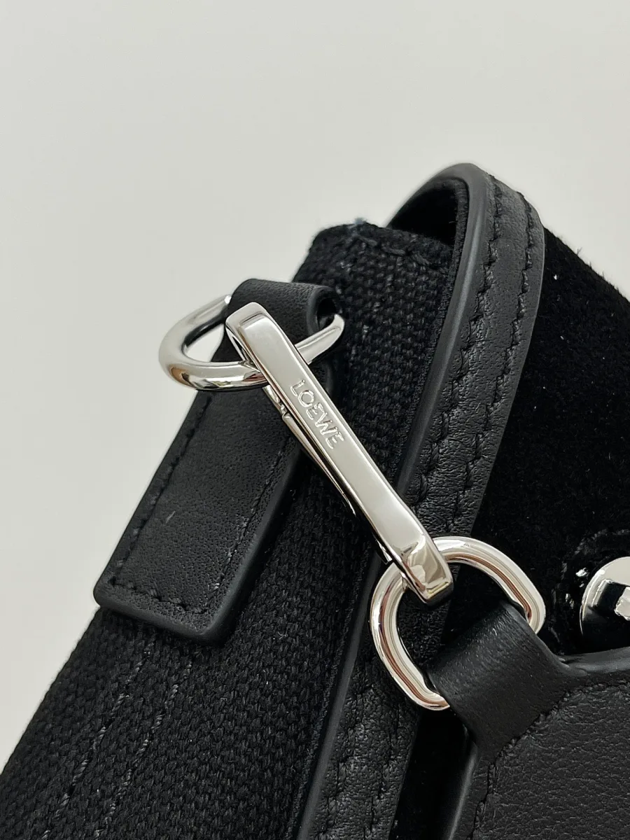 Деталь крепления широкого текстильного ремня к сумке Loewe серебристым карабином