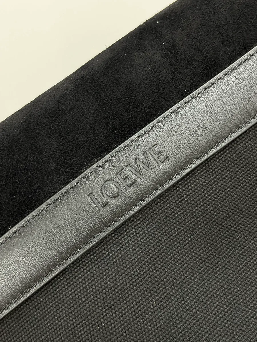 Кожаная планка с тиснёным логотипом LOEWE на задней стороне сумки, крупный план