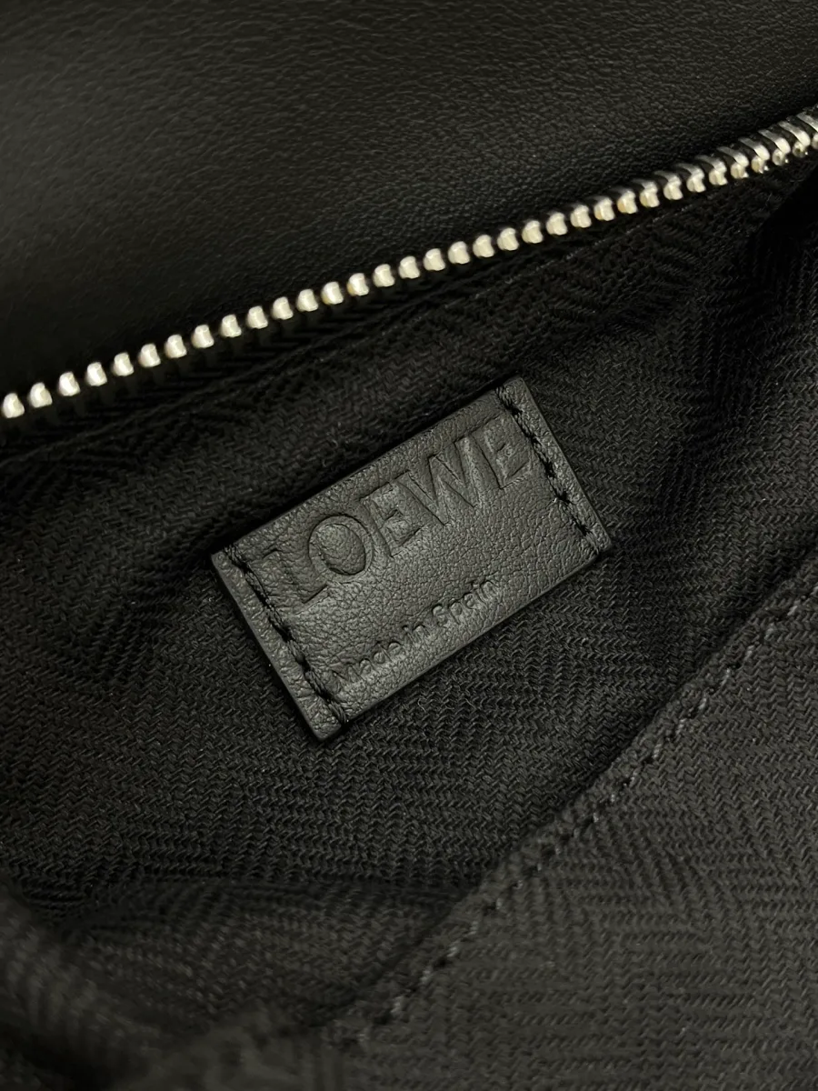 Внутренняя кожаная нашивка с тиснением Loewe на тёмной тканевой подкладке