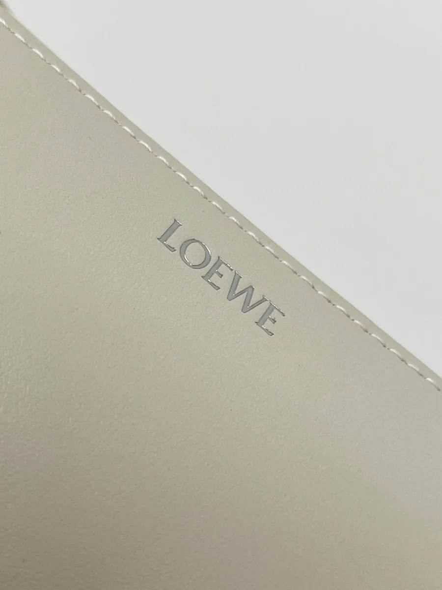 Крупный план серебристого тиснения логотипа Loewe на коже