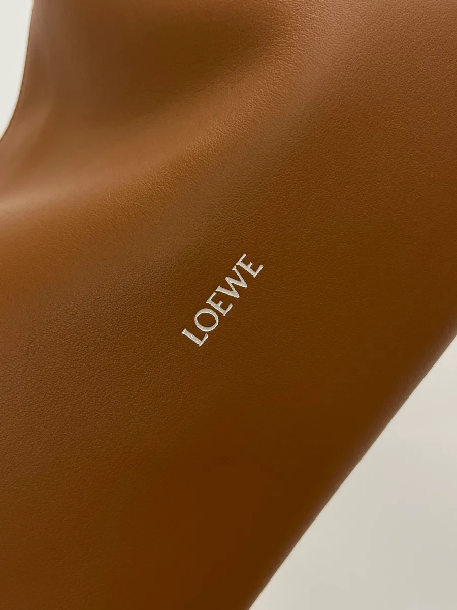 Тиснение логотипа Loewe серебристого цвета на гладкой коричневой коже