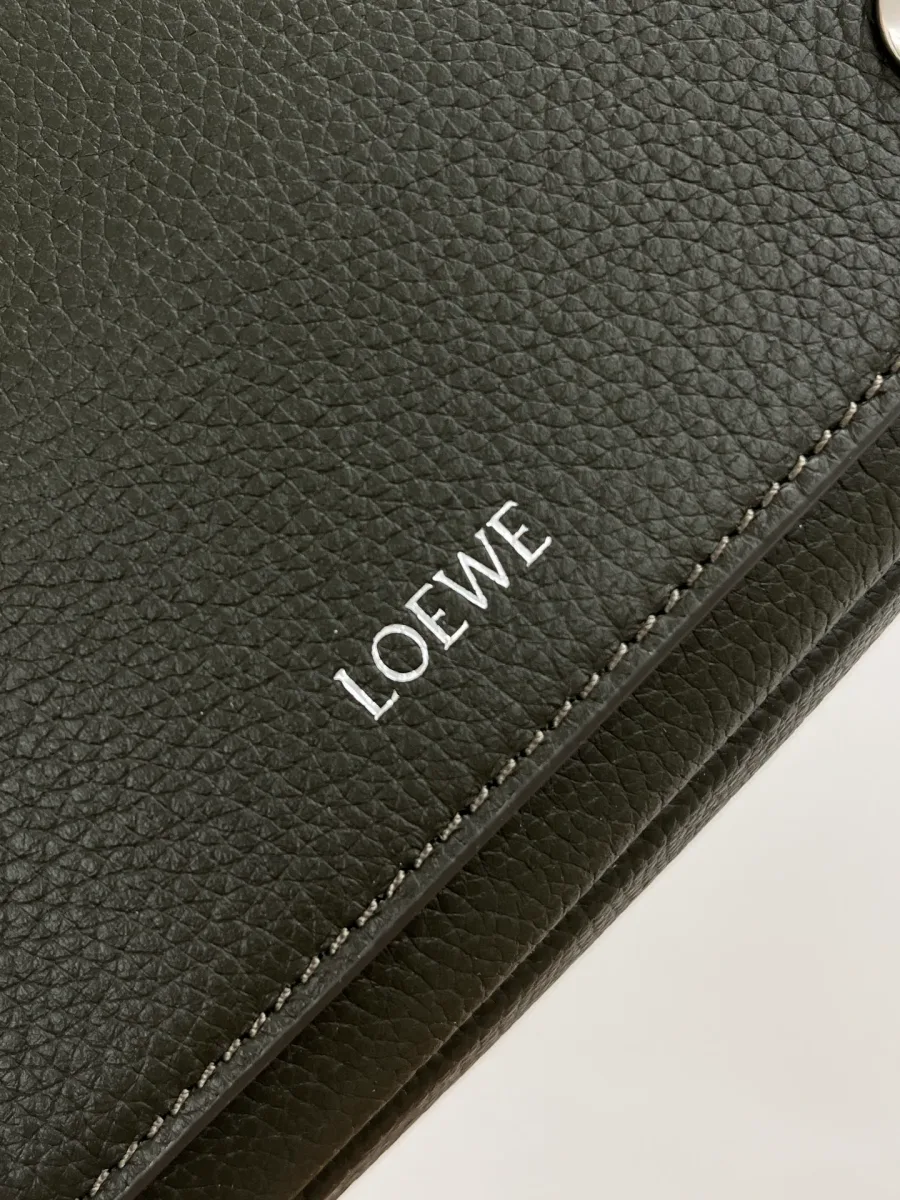 Крупный план клапана кармана с серебристым тиснением Loewe на зернистой коже