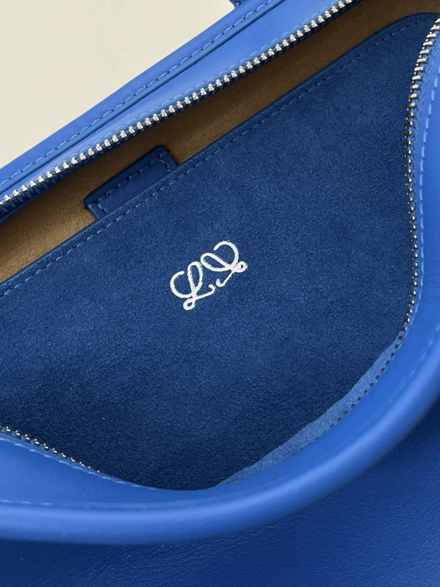 Внутреннее отделение синей сумки Loewe с тиснением фирменной анаграммы