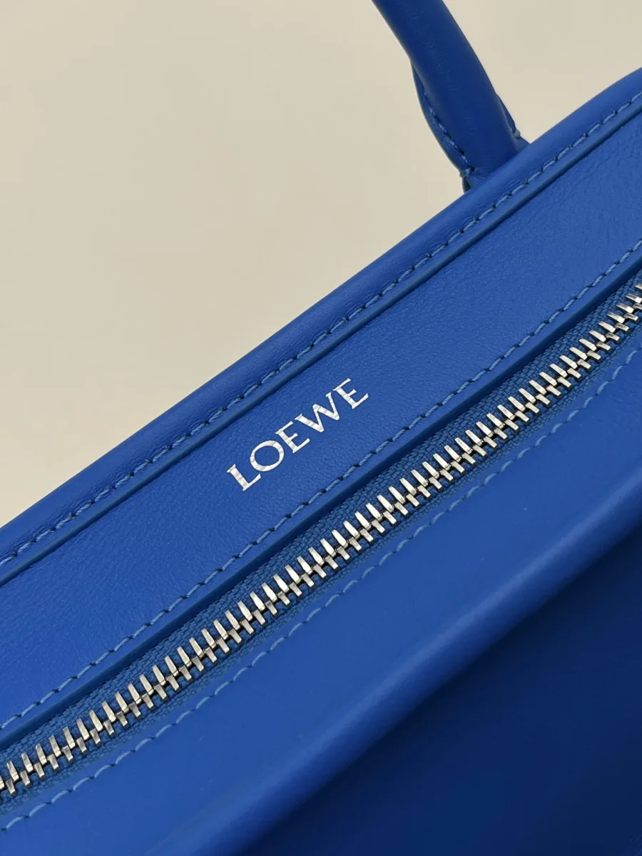 Серебристая застёжка-молния и тиснёный серебристый логотип Loewe на синей коже