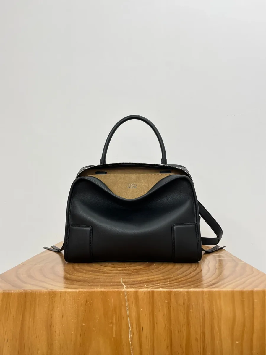 Чёрная кожаная сумка Loewe Amazona 180 Medium, вид спереди на деревянной подставке