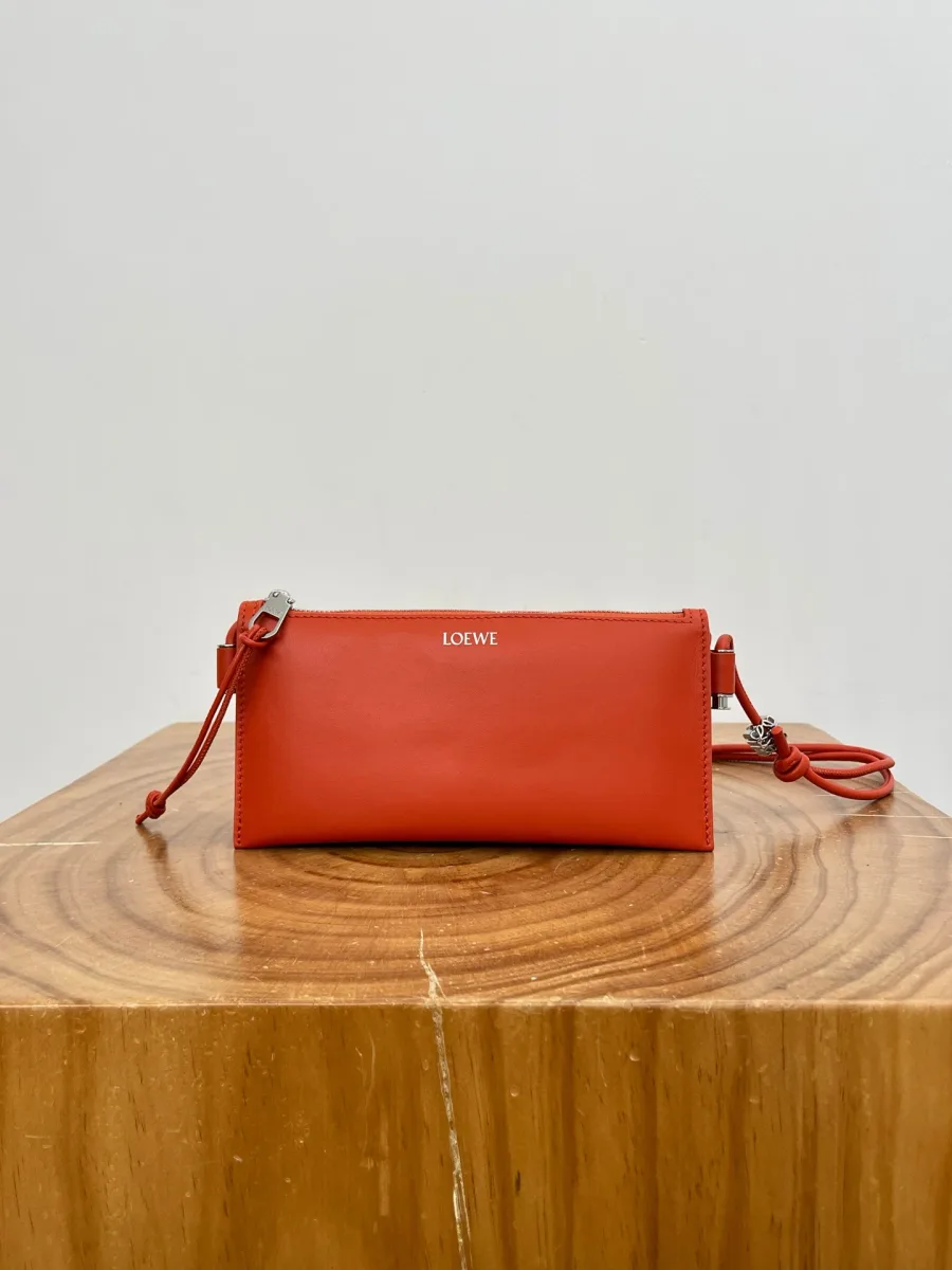 Оранжевая кожаная сумка Loewe Joya на деревянной подставке, фронтальный ракурс