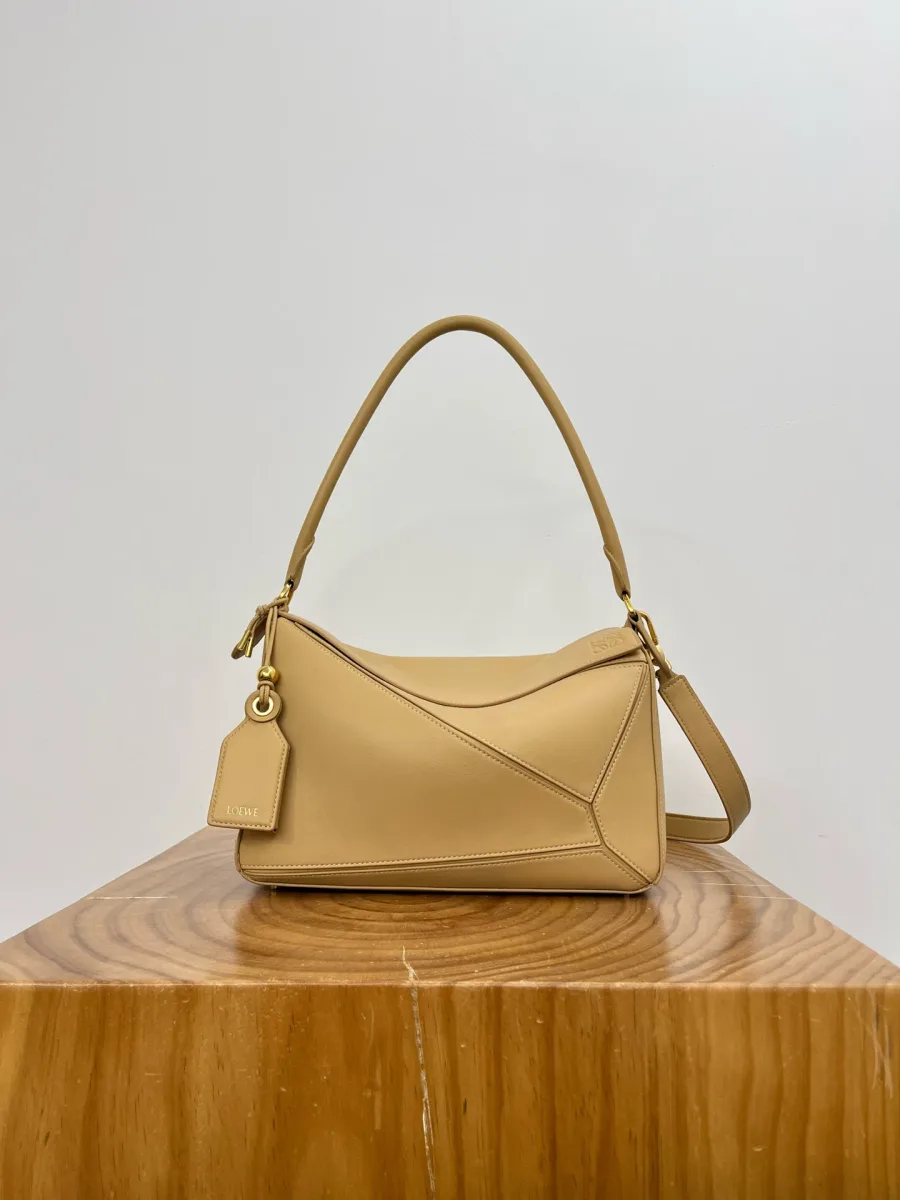 Сумка Loewe Puzzle светло-жёлтого цвета, вид спереди на деревянной подставке