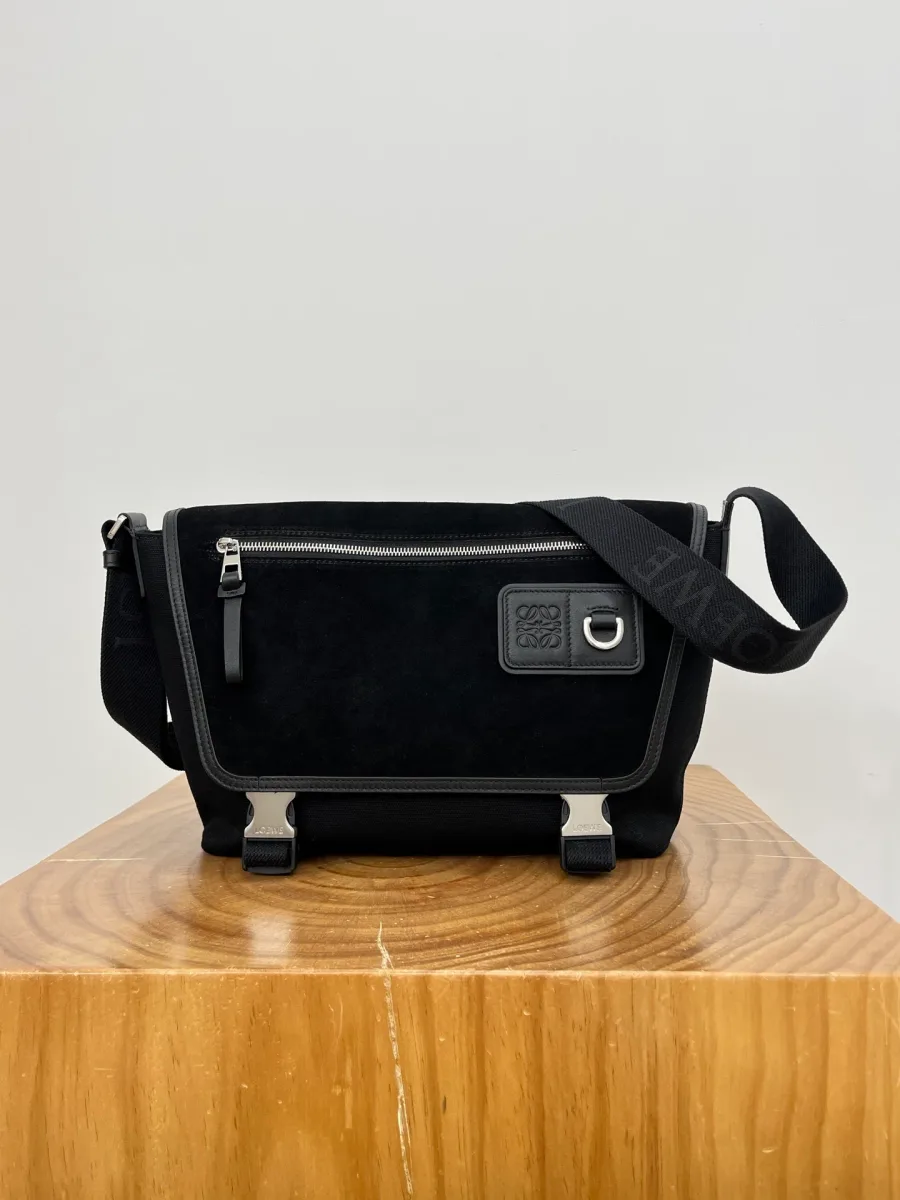 Чёрная сумка-мессенджер Loewe Flex из замши и канваса, вид спереди на деревянной подставке