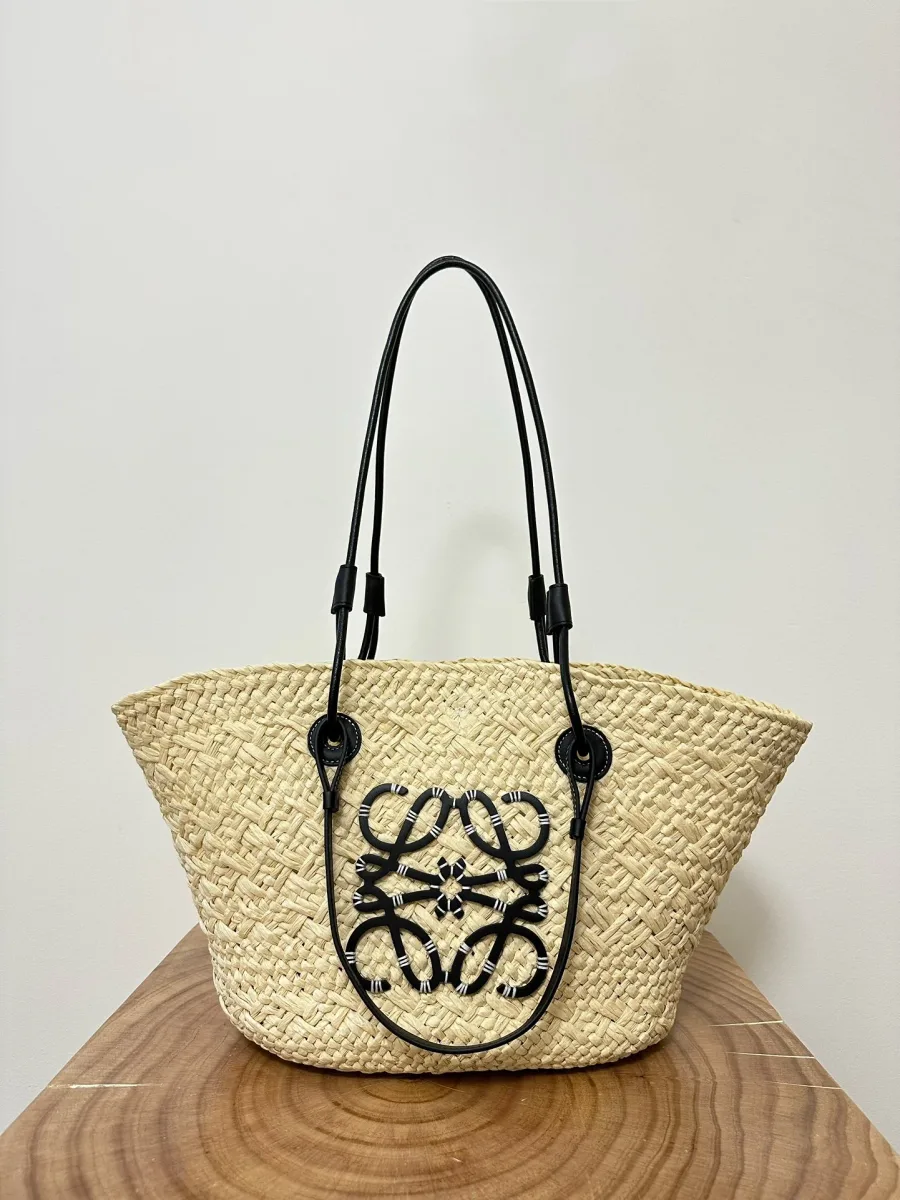 Плетёная сумка Loewe Anagram Basket из пальмовых волокон с поднятыми чёрными ручками, фронтальный ракурс