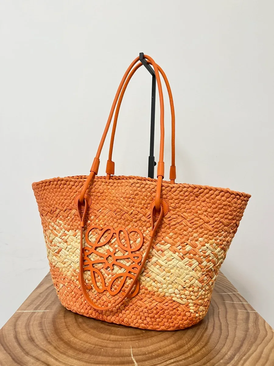 Плетёная сумка Loewe Anagram Basket оранжевого цвета, ракурс три четверти