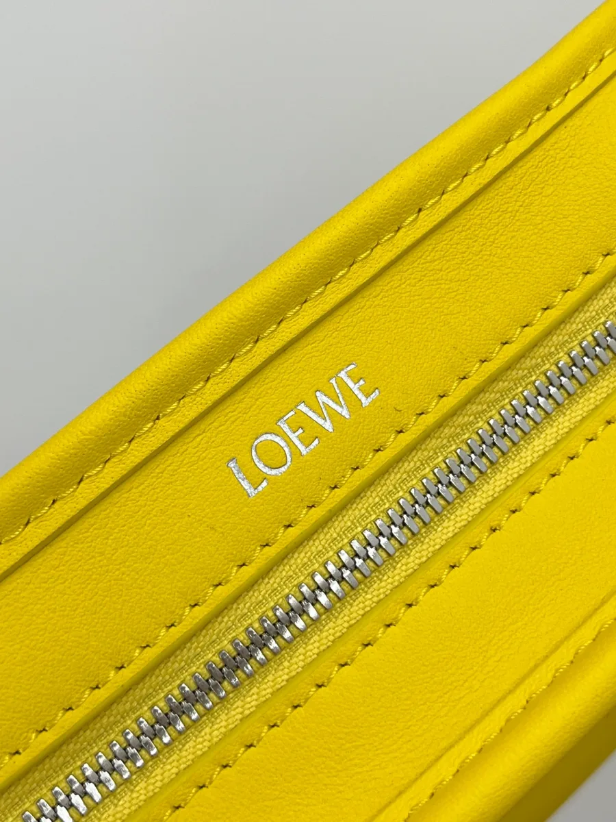 Крупный план серебристой молнии и тиснения с названием бренда Loewe