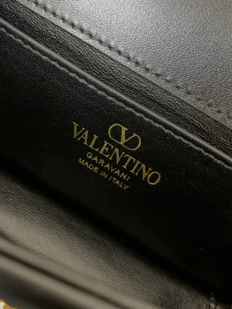 Тиснение золотистого логотипа Valentino Garavani на внутренней стороне сумки