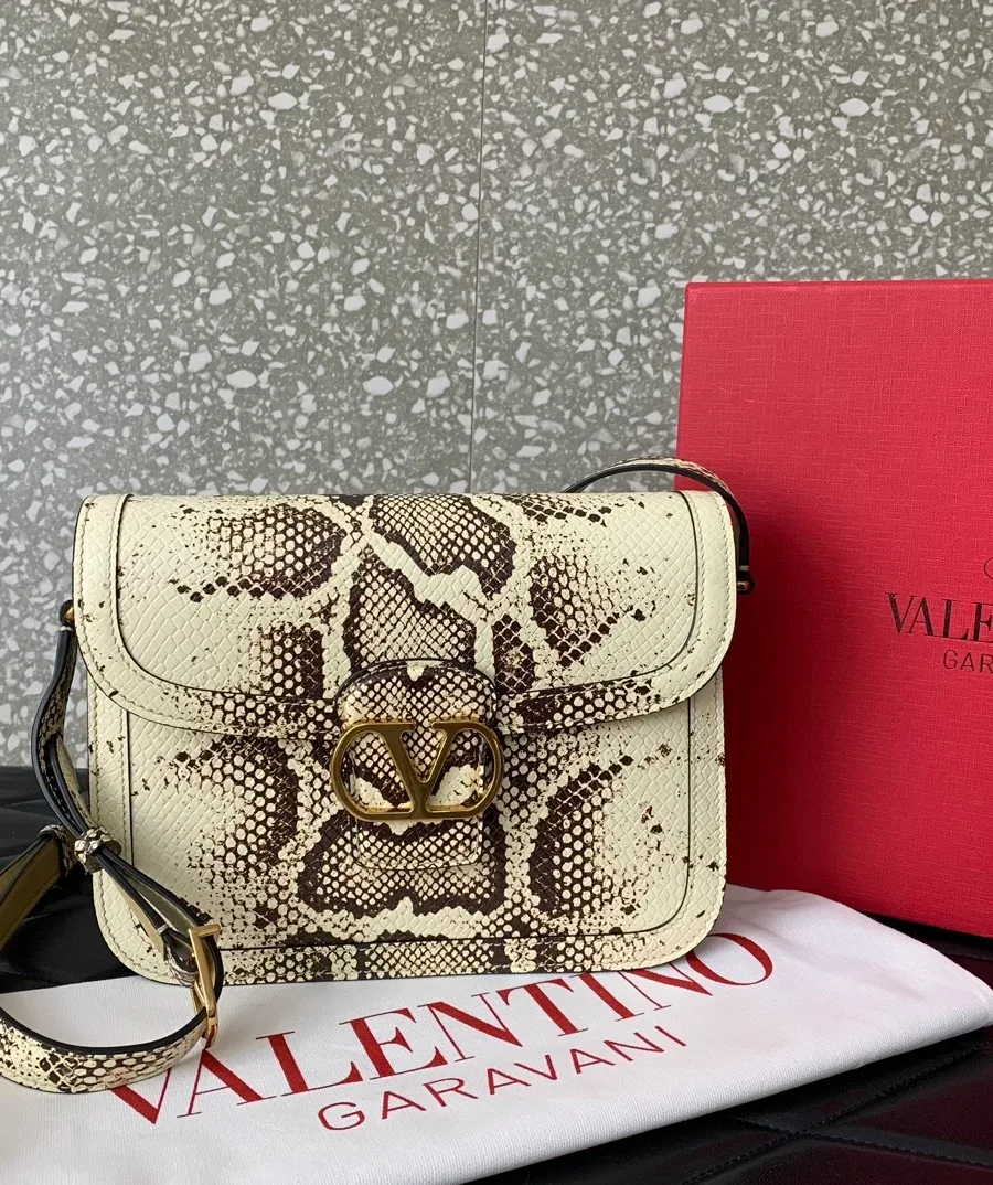 Сумка Valentino на фоне фирменного пыльника и брендовой коробки