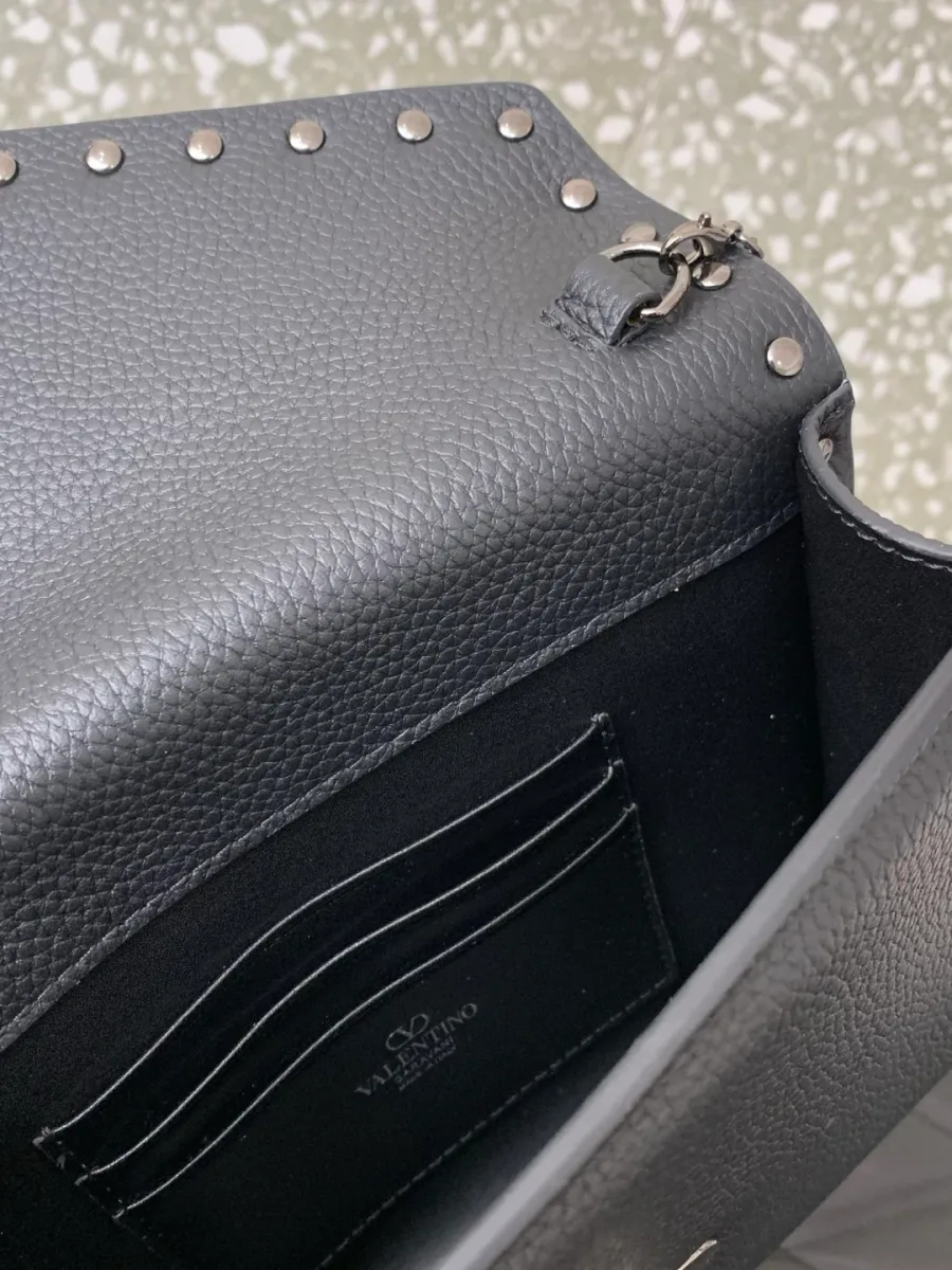 Внутреннее отделение сумки Valentino Rockstud с кожаными слотами для карт и тиснёным логотипом