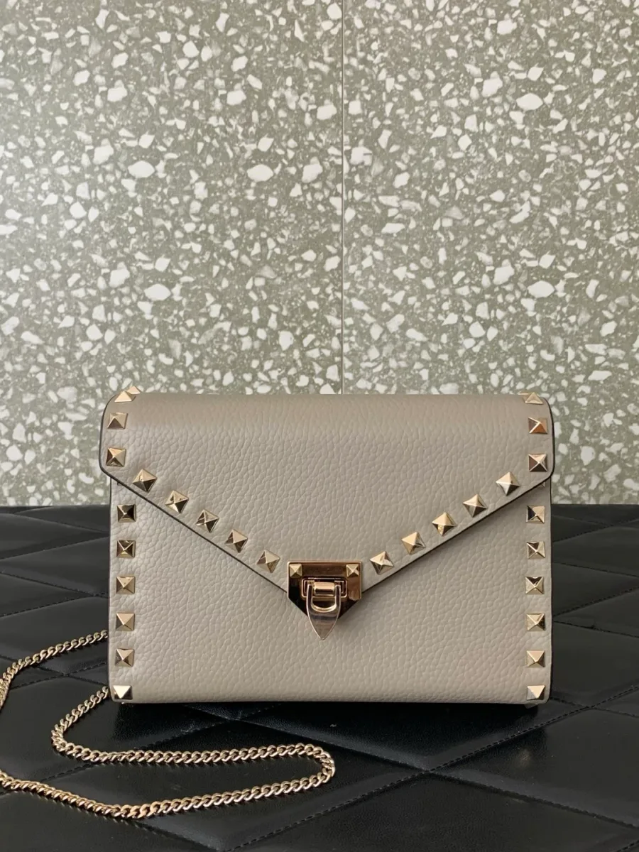 Бежевая сумка с шипами Rockstud и золотистым замком на цепочке, вид спереди