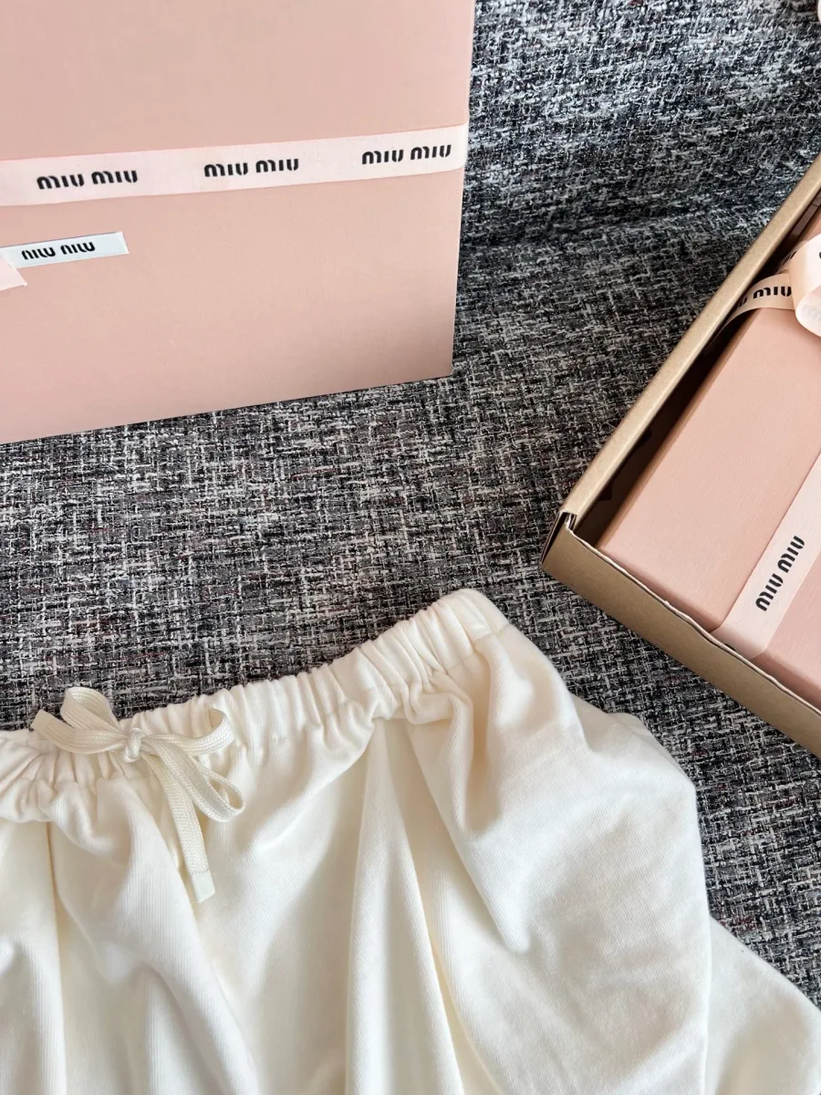 Вышитый логотип Miu Miu на белой ткани