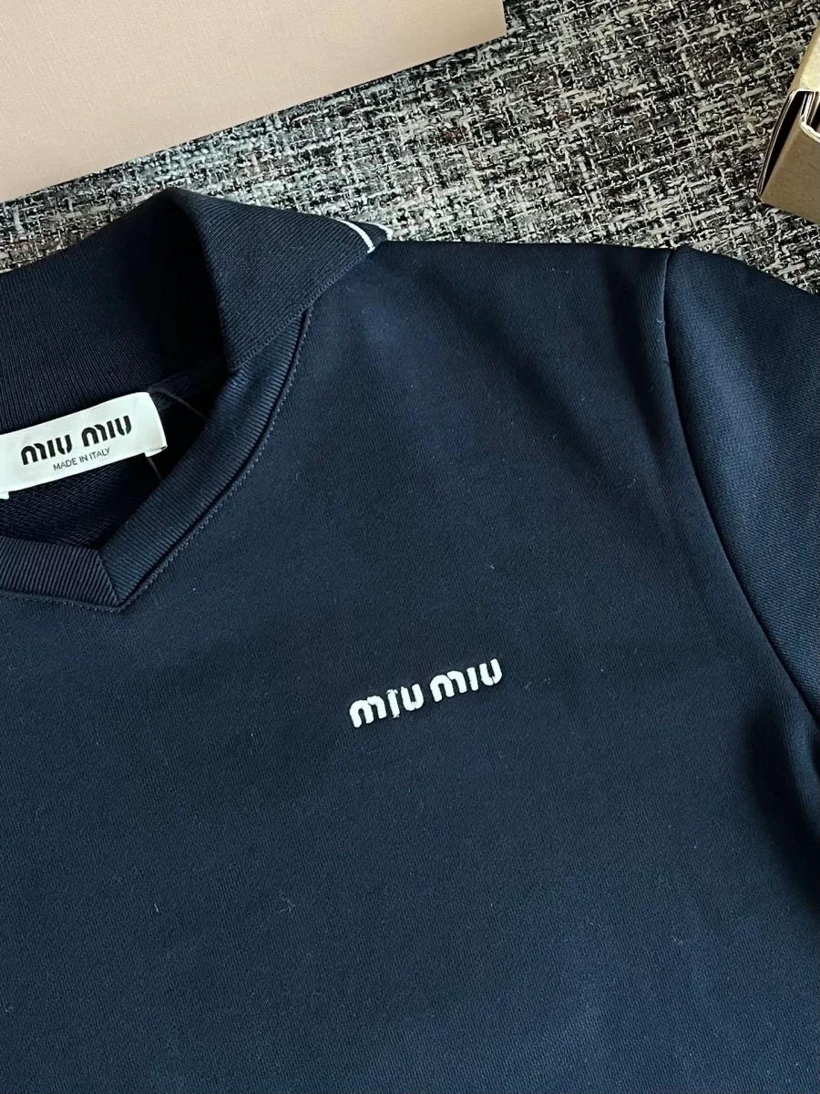 Вышитый белый логотип Miu Miu на груди и вырез горловины крупным планом