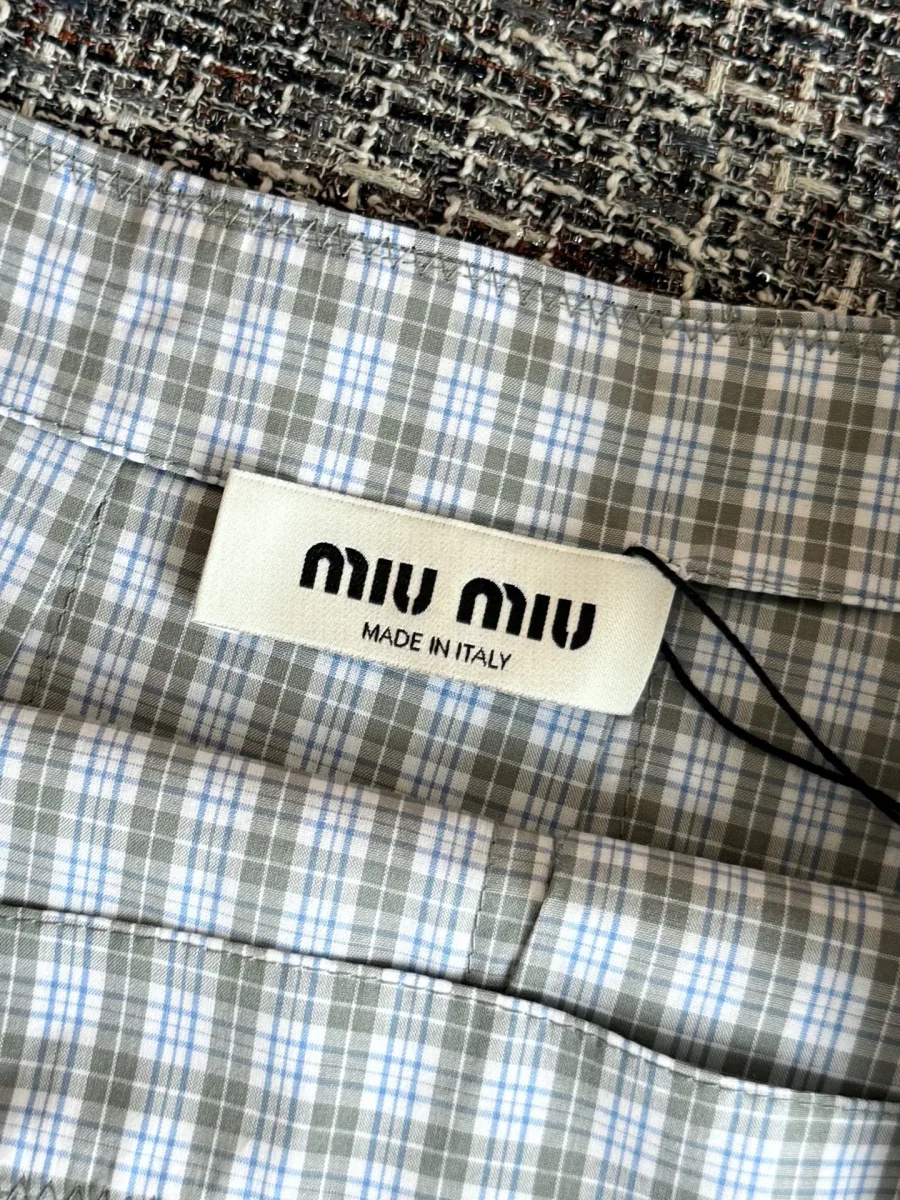 Внутренняя бирка Miu Miu на поясе клетчатой юбки крупным планом