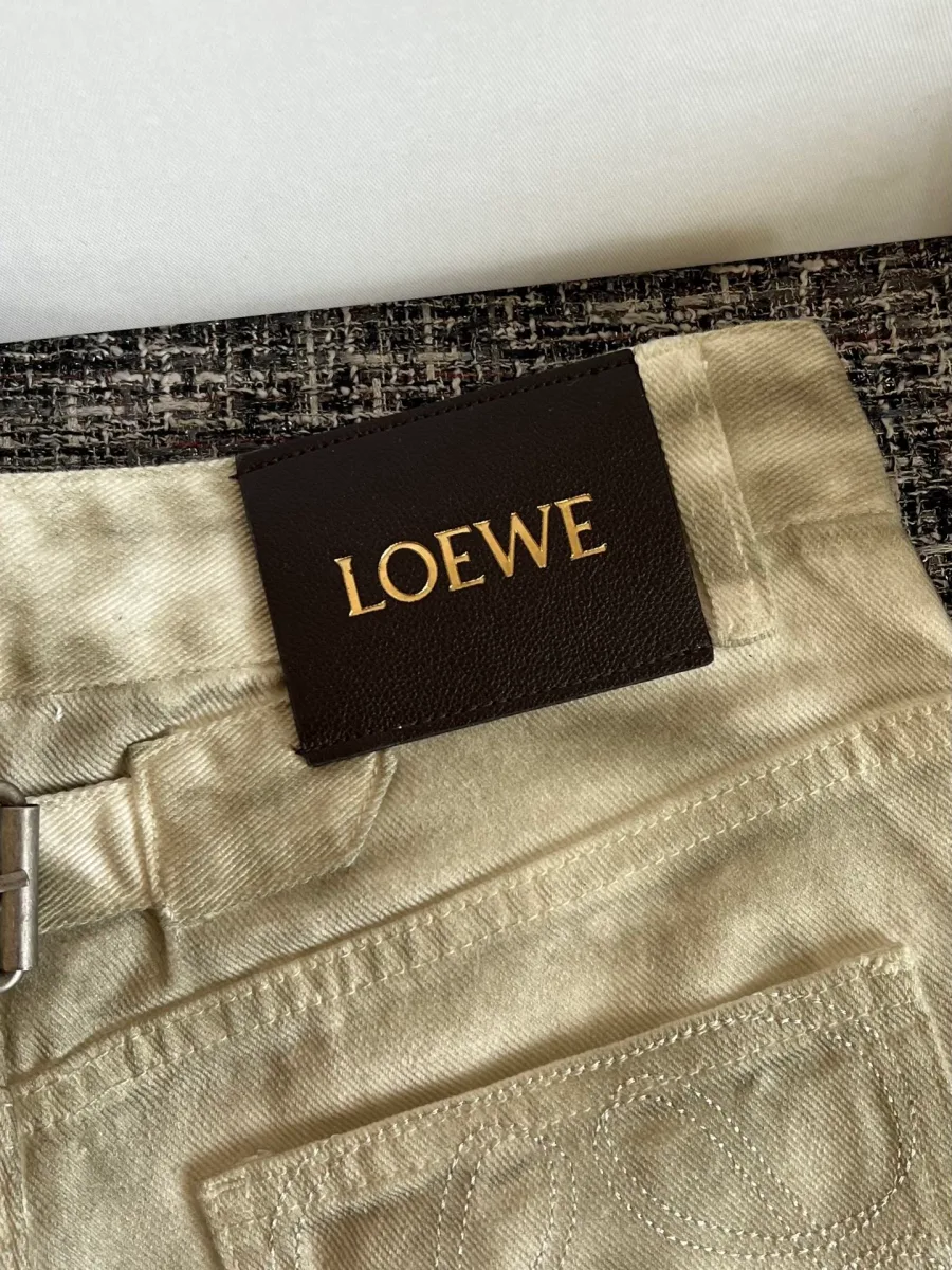 Кожаный патч с логотипом бренда и хлястик на поясе сзади