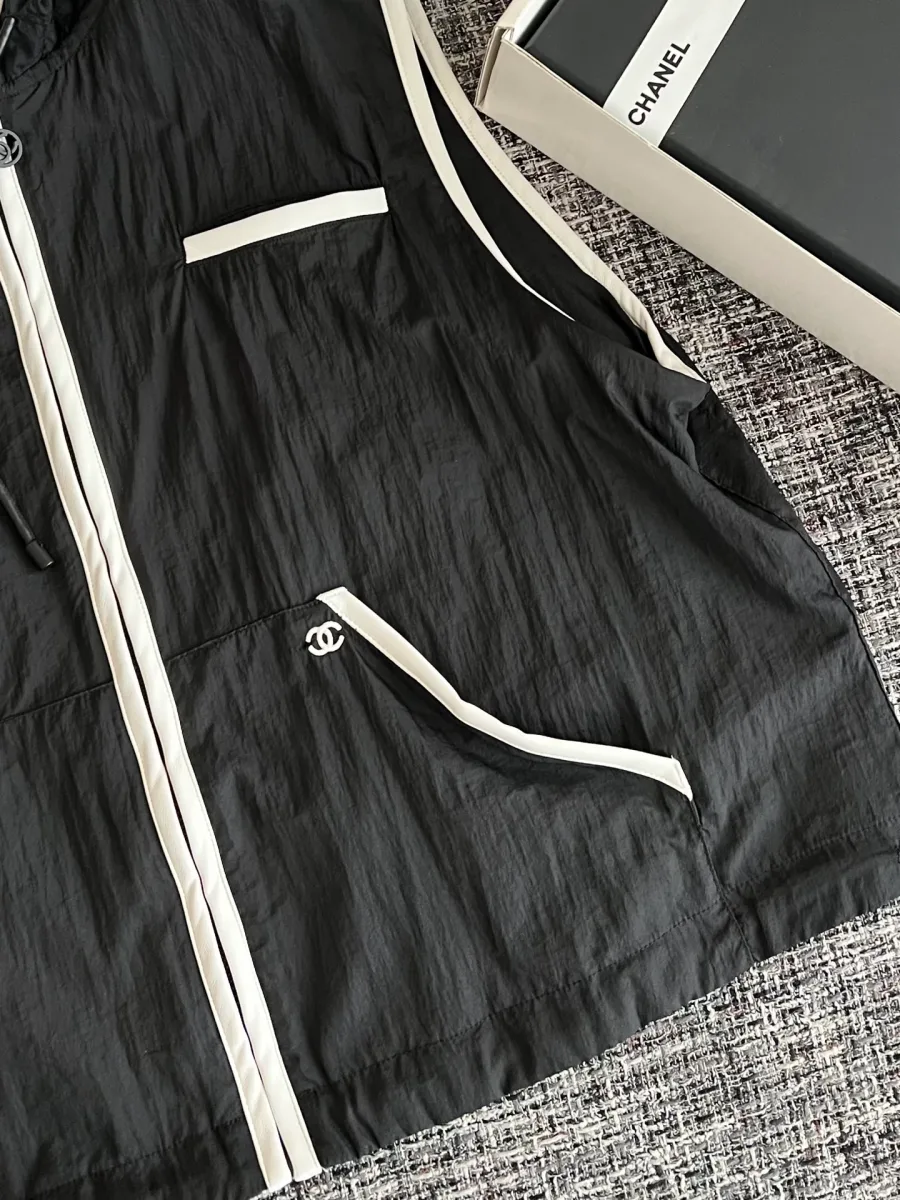 Боковой карман чёрного жилета с белым кантом и логотипом CC