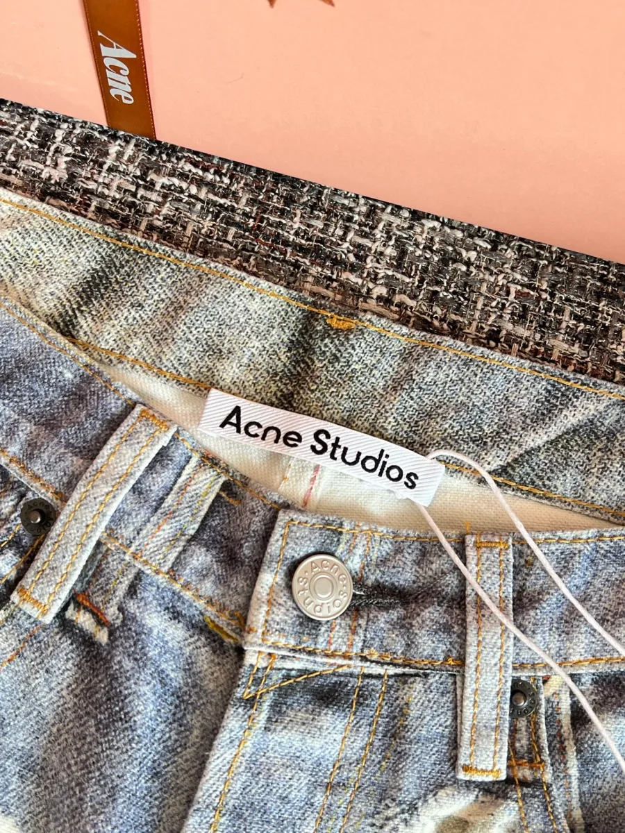 Пояс джинсов со шлёвками, металлической пуговицей и текстильным ярлыком