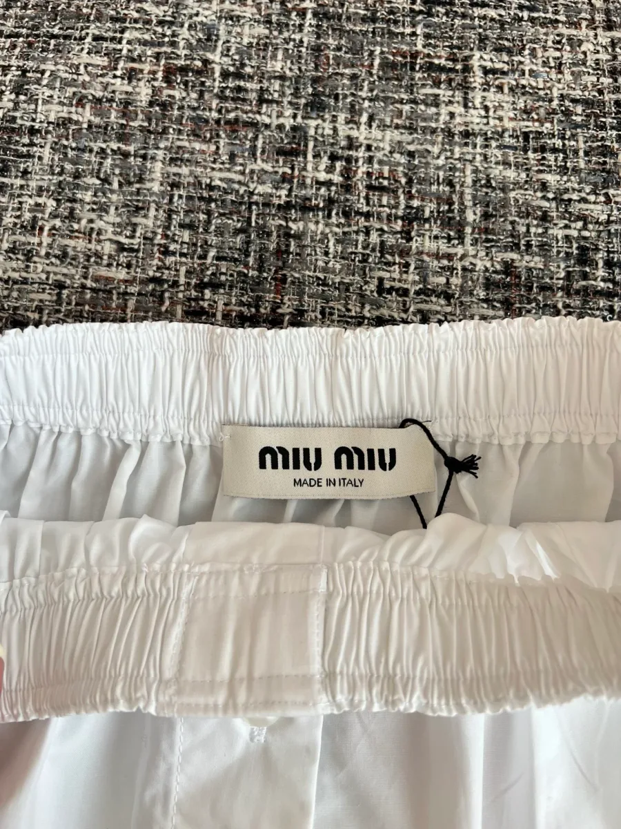 Внутренний ярлык бренда Miu Miu на эластичном поясе юбки