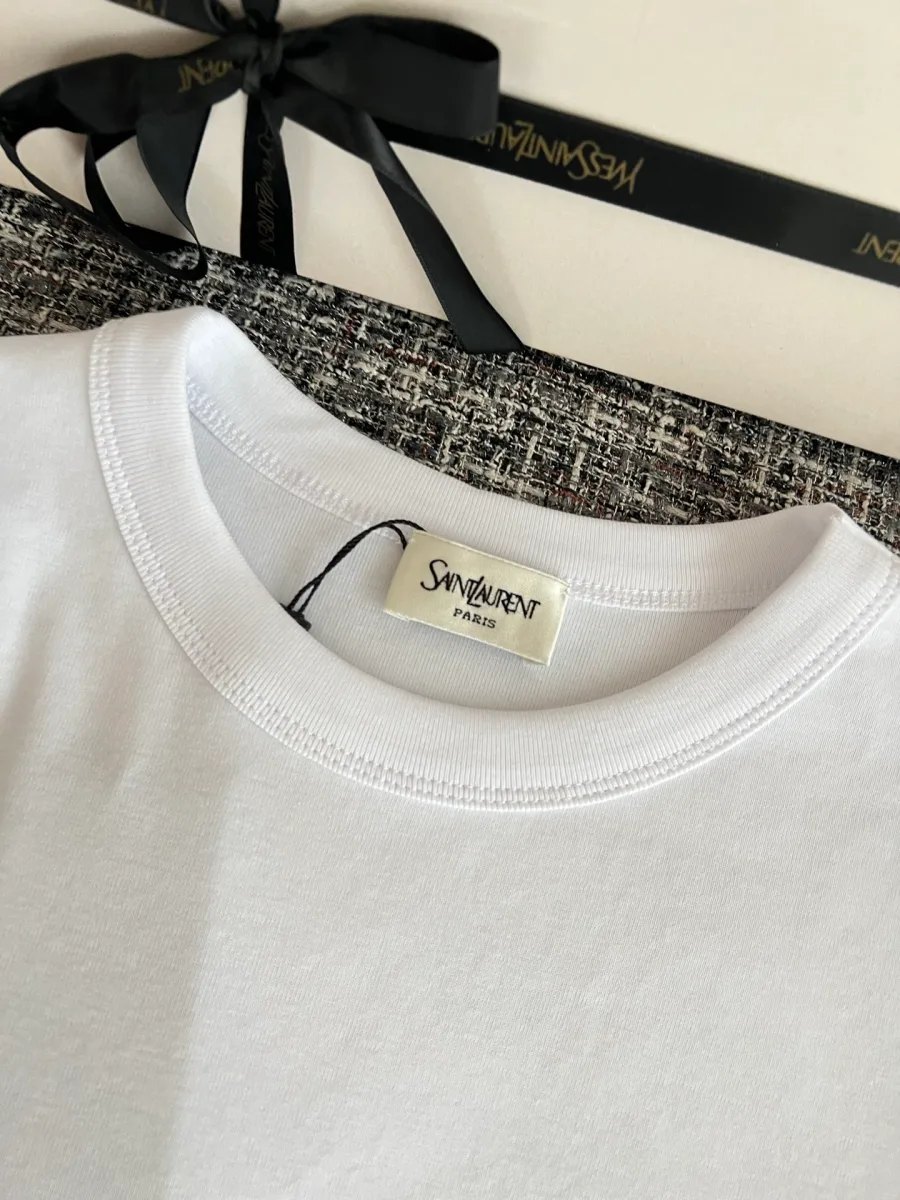 Круглый вырез горловины белой футболки с брендовой биркой Saint Laurent
