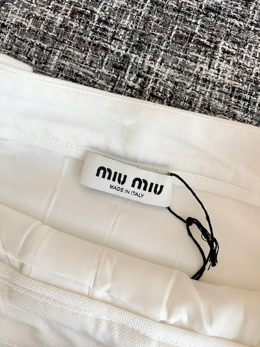 Внутренний ярлык с логотипом Miu Miu на поясе белой юбки