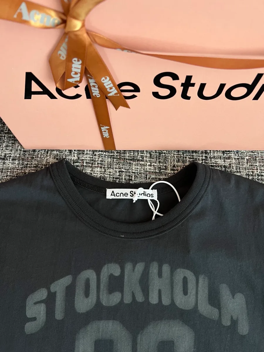 Воротник и верхняя часть чёрной футболки с принтом Stockholm 96