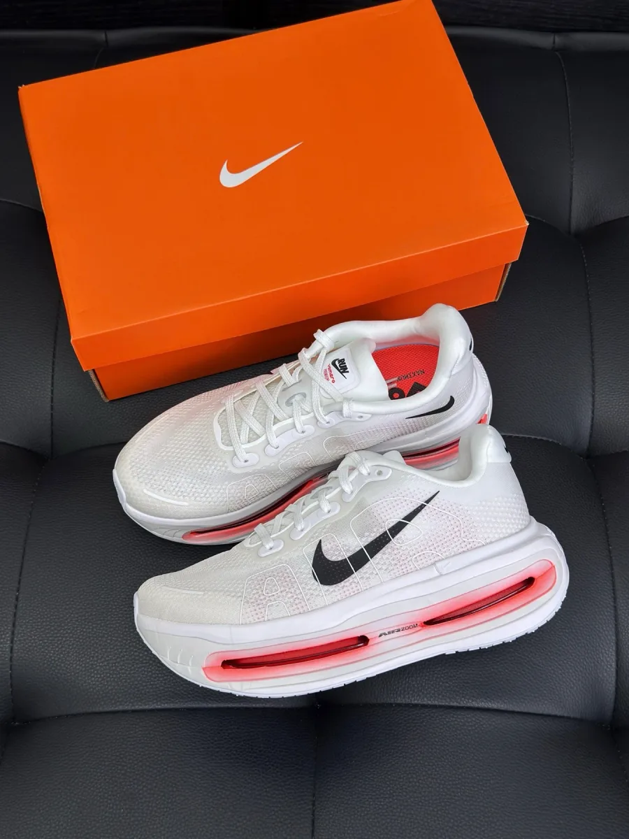Белые кроссовки Nike Vomero Premium рядом с фирменной оранжевой коробкой