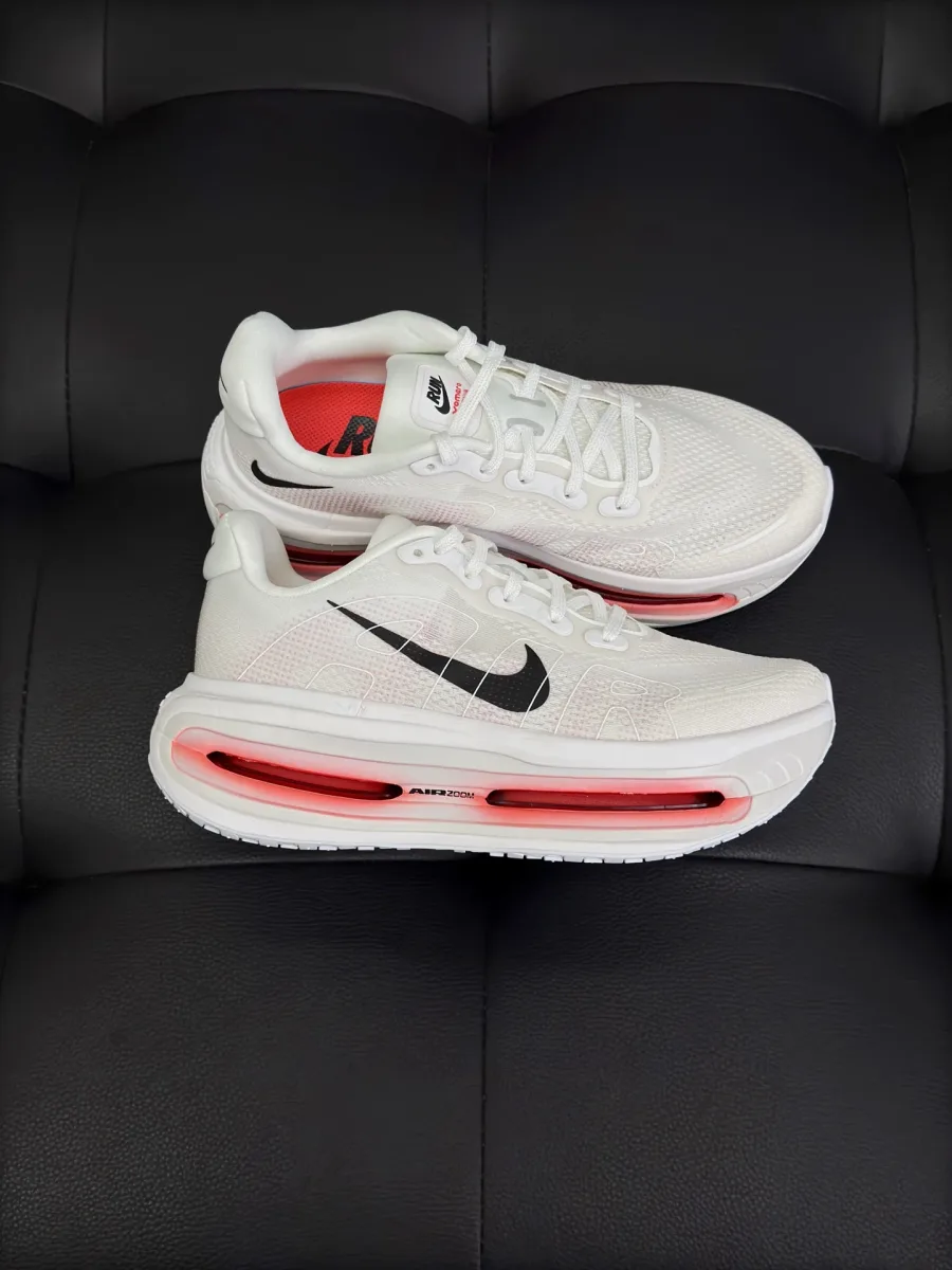 Пара белых кроссовок Nike Vomero Premium, ракурс сбоку три четверти