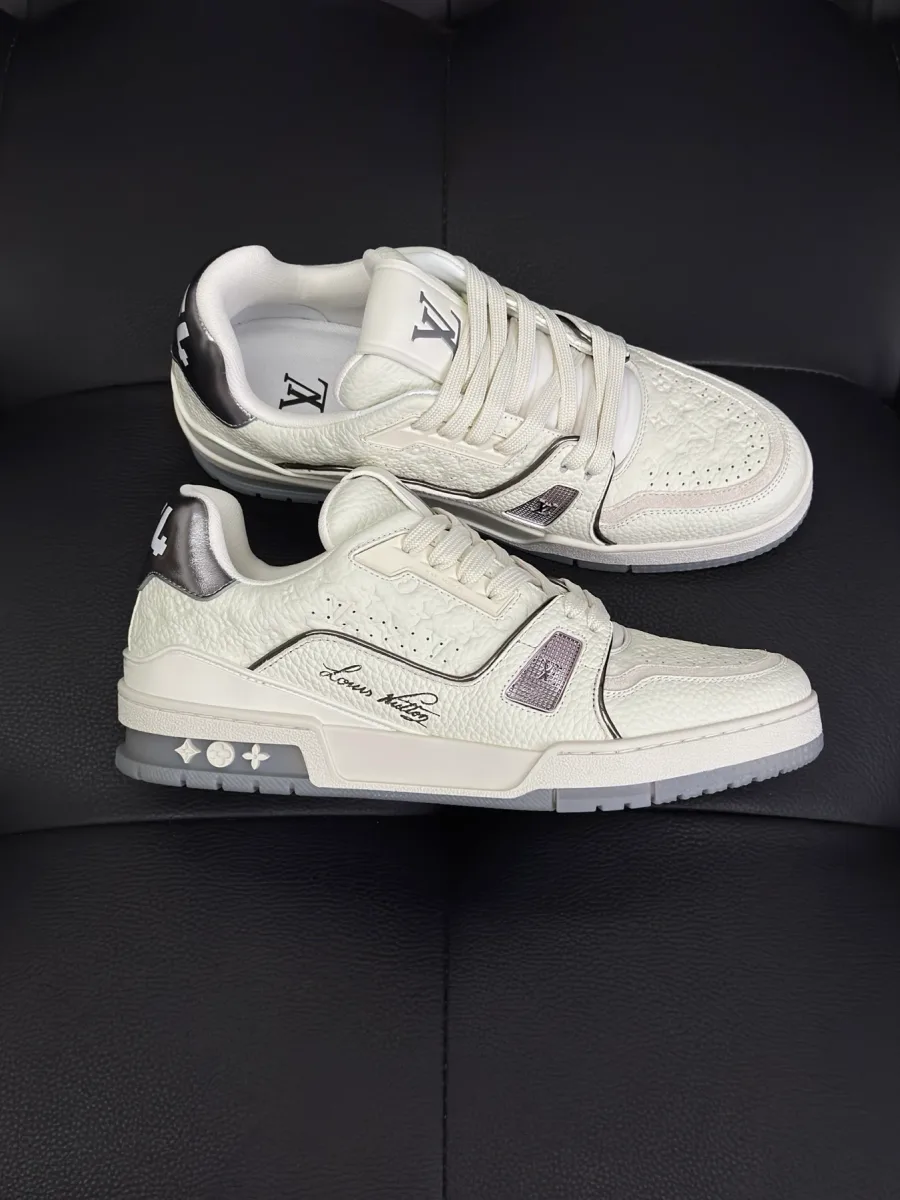 Белые кроссовки LV Trainer с серебристыми деталями и надписью, вид сбоку