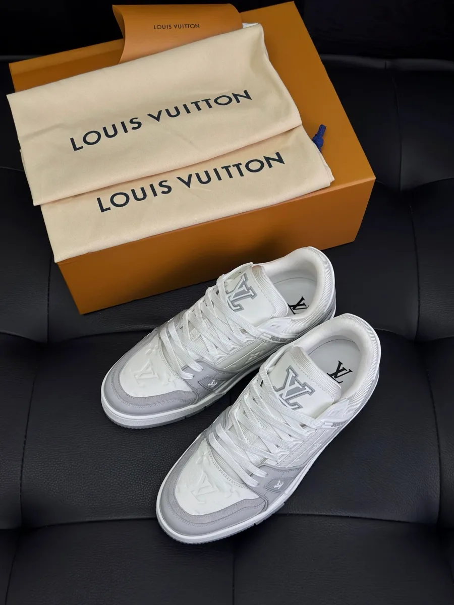 Бело-серые кроссовки LV Trainer рядом с пыльниками и коробкой