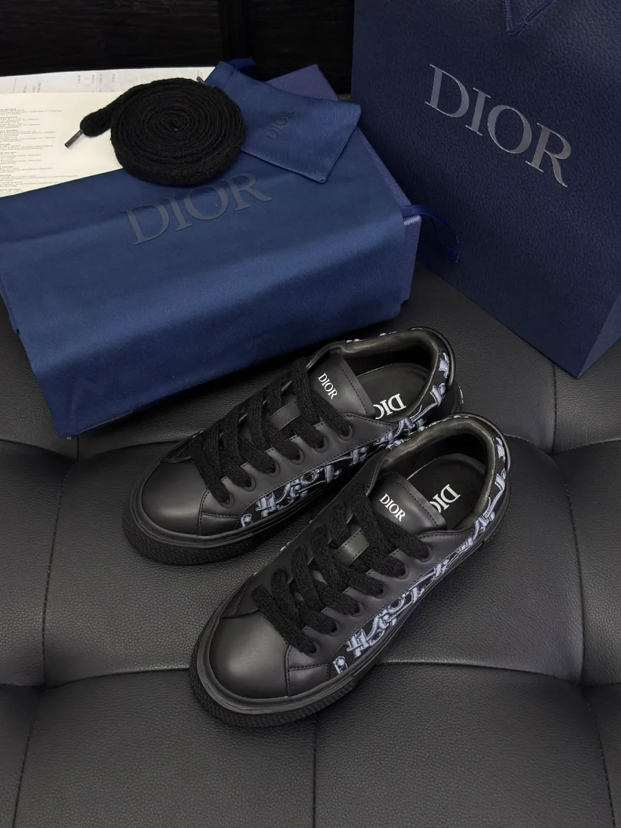 Чёрные кеды Dior B33 рядом с фирменной синей коробкой и пакетом