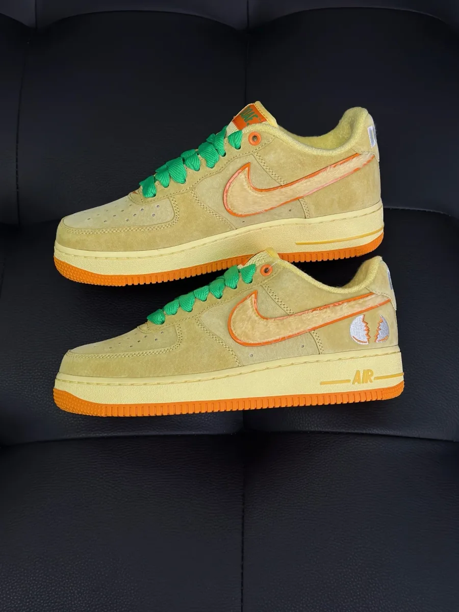Пара жёлтых низких кроссовок из замши с оранжевыми логотипами Swoosh, вид сбоку