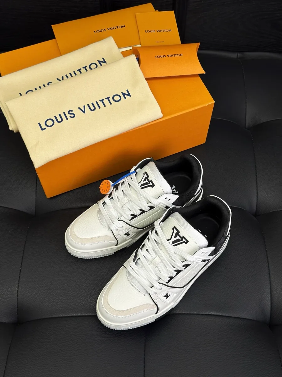 Бело-чёрные кроссовки LV Trainer рядом с фирменной коробкой и пыльниками