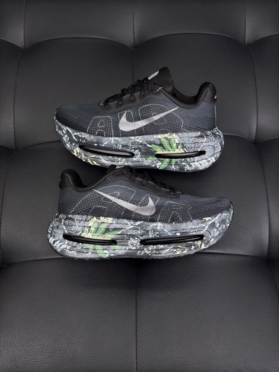 Пара чёрных кроссовок с серебристым логотипом Swoosh, вид сбоку