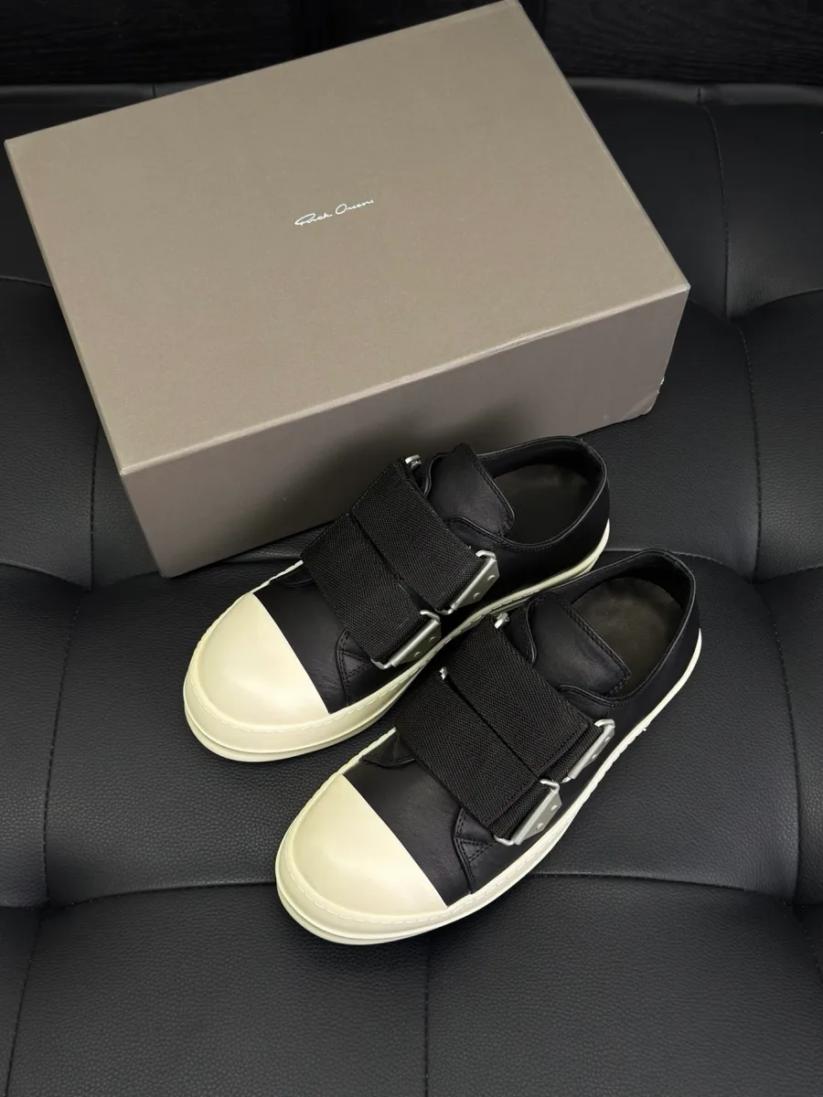 Чёрные низкие кеды с ремешками на липучках рядом с фирменной коробкой