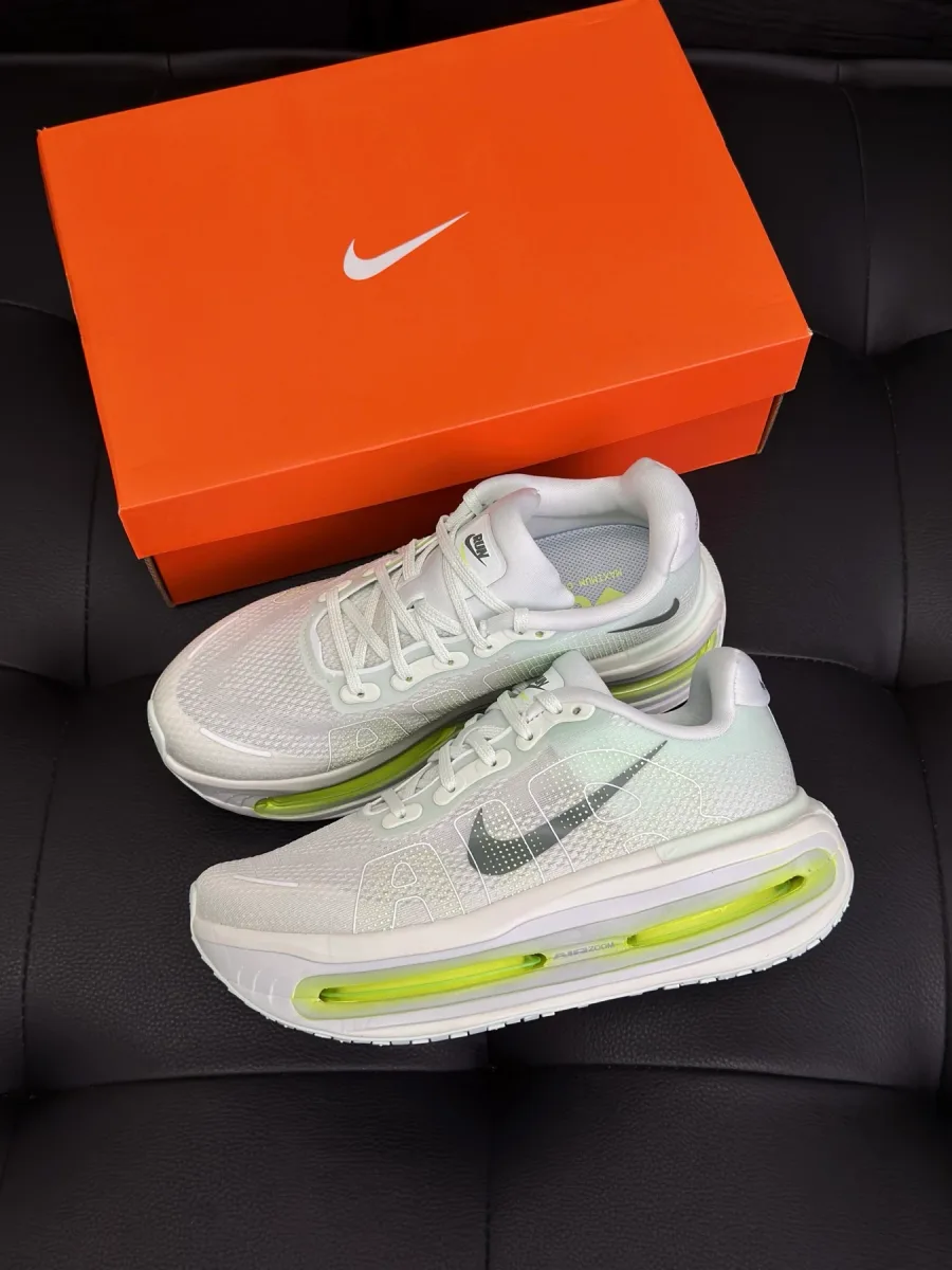 Кроссовки Nike Vomero Premium белого цвета рядом с фирменной оранжевой коробкой
